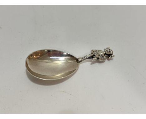 A Birmingham silver caddy spoon with horned mythical beast handle, (L x 8cm) Birmingham 1936. 22.8g