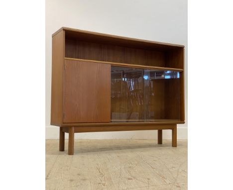 McIntosh, a mid century teak bookcase, with open shelf above two sliding glazed doors enclosing an adjsutable shelf, flanked 