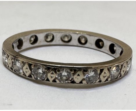 A white metal and yellow metal eternity style ring set sixteen diamond points, one stone damaged, in claw setting, ring shape