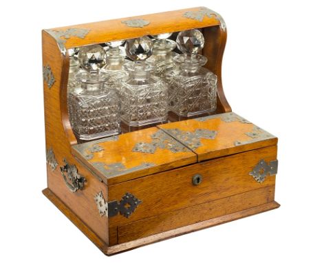 A Late Victorian/Edwardian Tantalus and Gaming Set:The frame applied with strapwork and carrying side handles, with fitted pa