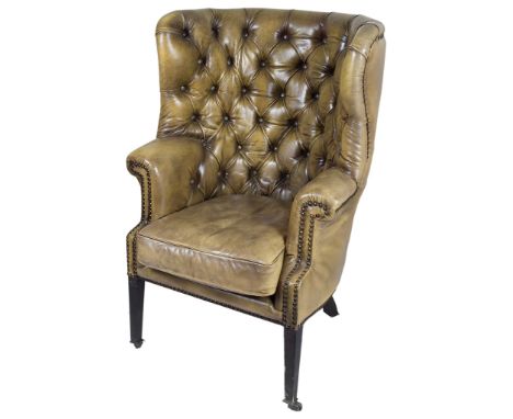 A Leather Armchair:With arched button back design, on four tapered legs and castors, H 116cm x W 76cm   CONDITION REPORT:  Go