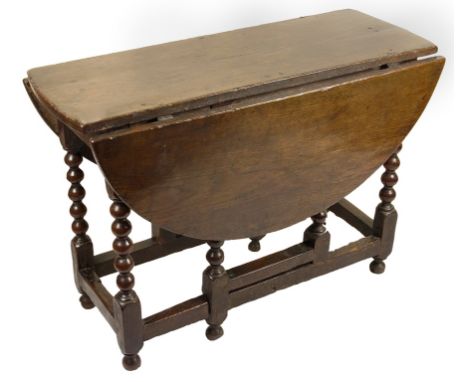 A 17th Century Oak Gate Leg Table:On six pullout type turned legs, H 80cm x W 37cm