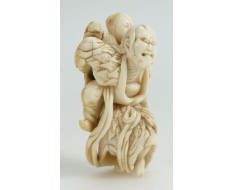 19th century Japanese carved Netsuke peasant carrying son, length 7.5cm.
