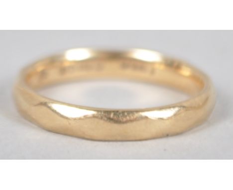 A yellow metal 3.0mm wedding ring having a diamond faceted design. Hallmarked 9ct gold, London, 2000. Size: L 2.4 grams