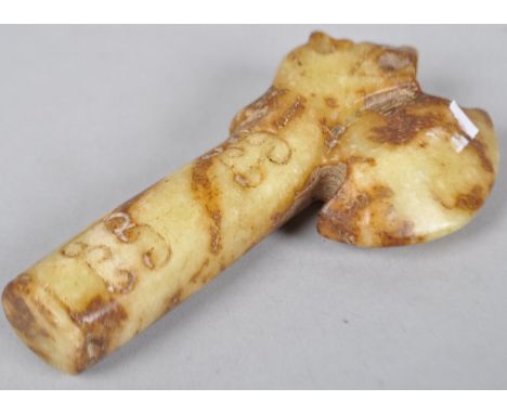 A jade carved axe head, mottled in brown and cream and carved with scrolls 11cm high