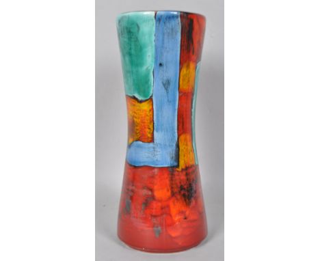 A Poole pottery gemstone hour glass vase, decorated in typical palette on a red ground by Andrew Tanner, 34cm high