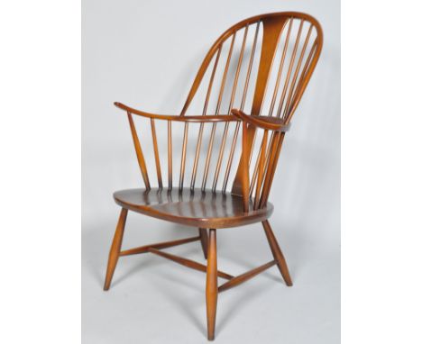 An Ercol dark Windsor armchair, model 514, 1960's, the high back with tapering splat and U-shape central bar on splayed legs 