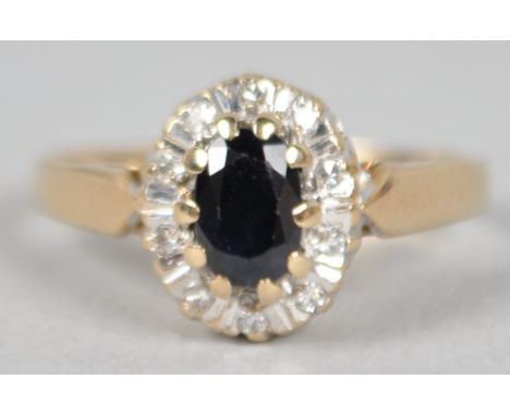 A yellow metal cluster ring. Principally set with an oval cut sapphire and surrounded by single cut diamonds estimated to wei