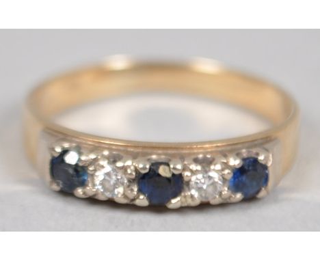 A yellow and white metal half hoop ring. Set with three round cut sapphires interspaced with two round brilliant cut diamonds