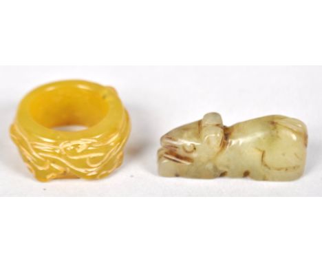 A jade thumb ring carved with a serpent and carving of a rat in mottled colour.