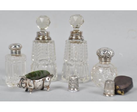 A silver cased thimble, Birmingham possibly 1890, with another uncased, a silver pig pin cushion, and four silver topped scen