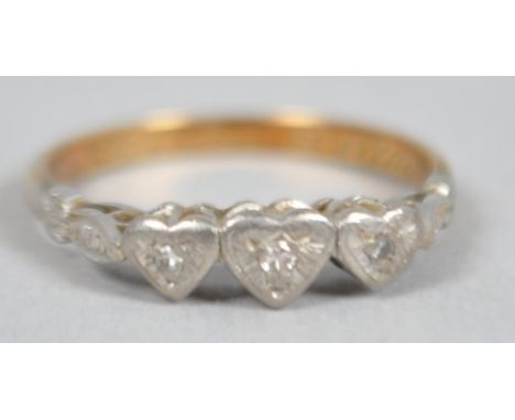 A yellow and white metal ring. Having a triple heart design and illusion set with single cut diamonds. No hallmark - stamped 