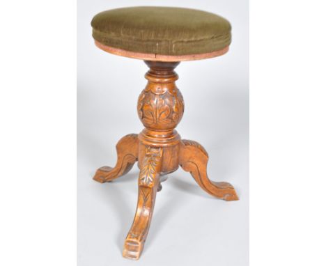 A Victorian revolving piano stool, the carved oak baluster support on three carved cabriole legs, 47cm high, 38cm wide maximu