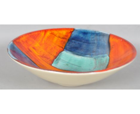 A Poole pottery gemstone centre bowl, decorated in typical palette on an orange ground, 9.5cm high, 33.5cm diameter