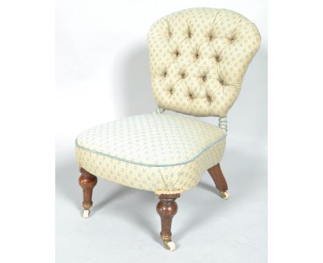 A Victorian button back nursing chair on turned mahogany legs on brass and ceramic casters, 70cm high, 44cm deep, 47cm wide