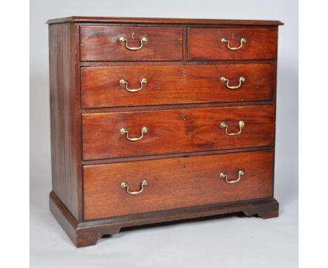 A George III mahogany chest of drawers, with two short and three long graduated drawers on ogee bracket feet, with brass swan