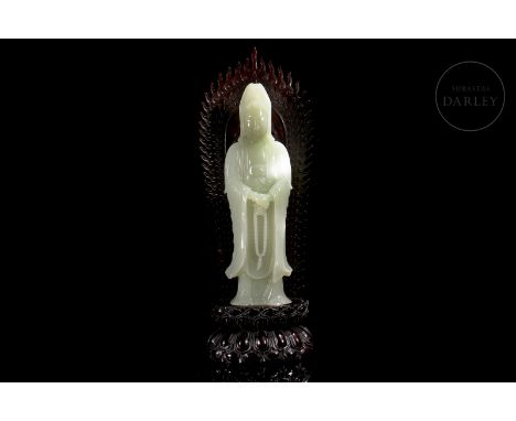 Representation of “Guanyin” made in carved white jade. It shows the hieratic deity, dressed in a long robe that covers from h