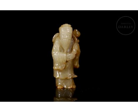 Carved Hetian jade figure, of ochre - caramel tone with reddish and brownish stains. It shows an old man dressed in long robe