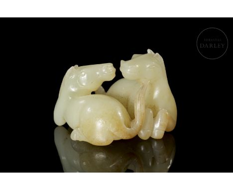 A light-coloured carved jade figure with reddish-gold spots and patina caused by ageing. The figure depicts two beautiful hor