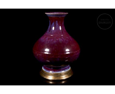 Ceramic vase with a circular base and a balustraded profile, standing on a flared foot. The body, slightly rounded, is decora