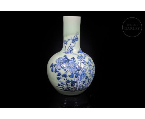 A ceramic vase, decorated with a light, fine glaze of a soft celadon hue with white and cobalt-blue relief decoration on top.