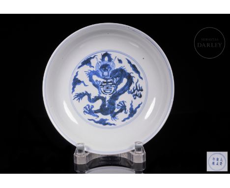 Porcelain dish with underglaze blue and white decorations covering the surface. The interior shows, inscribed in a double blu