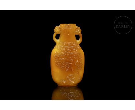 Carved amber snuff bottle. It has the shape of a vase with a flat profile, elongated and rounded body, which narrows at the n