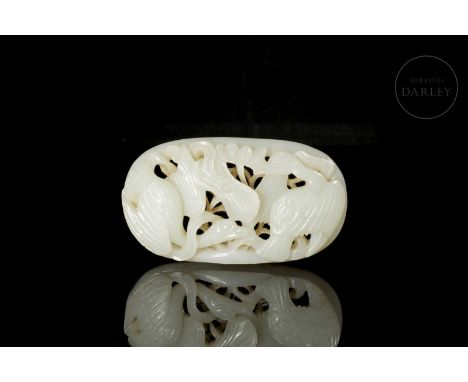 A small jade plaque with openwork and carved details, of a soft white hue. It is elliptical, with a rounded rim at the base. 