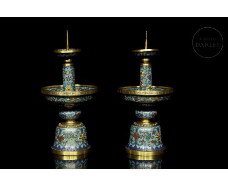 Pair of bronze candlesticks decorated with cloisonné enamel. They have a bell-shaped base, which rises to a flat, rounded bul