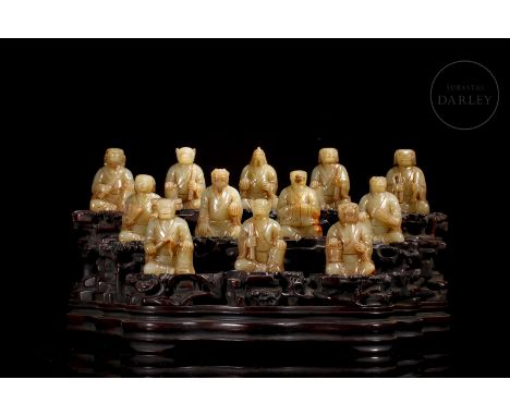 Set of twelve small carved Hetian jade figures, of ocher tonality with beautiful reddish stains arranged on a carved wooden b