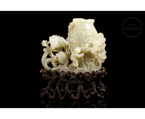 A superbly carved, light-coloured Hetian jade figure with soft reddish flecks. It depicts a scene full of dynamism, with beau