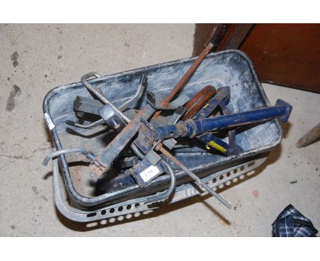 A tray of ladder lock downs, a pair of fold up axle stands, and a vintage tape measure.