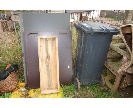 A wooden planter, wheelie bin and boards.