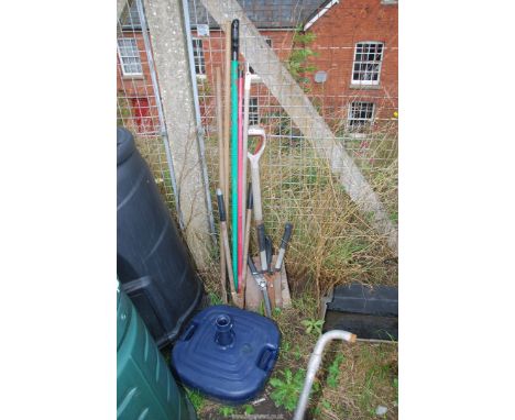 A quantity of garden tools, a parasol stand, etc.