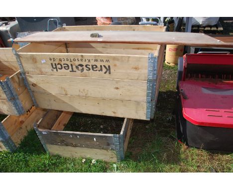 Five raised planter beds with a piece of teak board.
