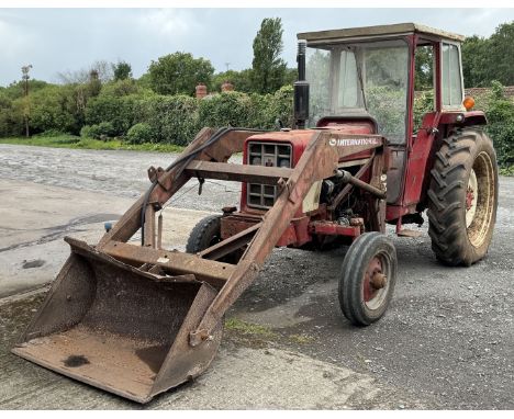 An International 574 HYDRO four-cylinder Diesel engine farm Tractor with safety cab, International Harvester loader and 40" w