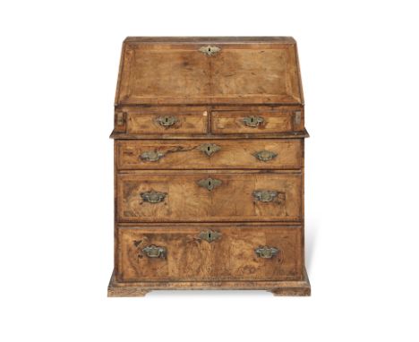 A George II walnut and featherbanded bureau of compact proportions1720-1735, the fall enclosing seven pigeon holes and six  d