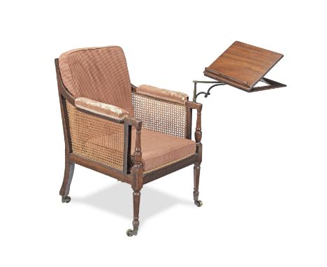 A Regency mahogany reading bergereCirca 1820, with caning, reeded toprail and conforming arm supports, one arm mounted with a