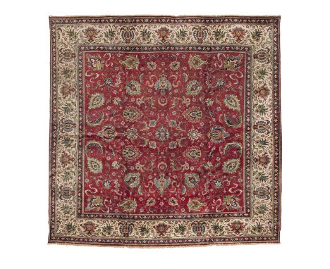 A Tabriz carpetNorth West Persia,of square proportions, the whole on rich red ground surrounded by ivory border,339cm x 329cm