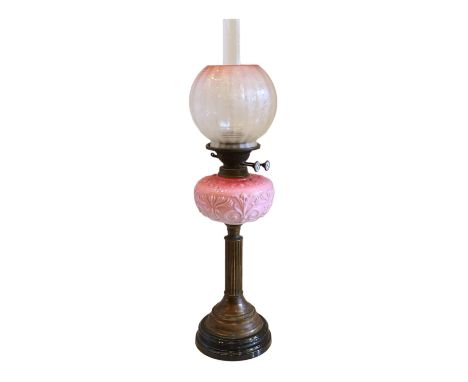 A late Victorian brass and black ceramic oil lamp with opaque moulded pink glass reservoir, Best Improved Duplex mechanism an