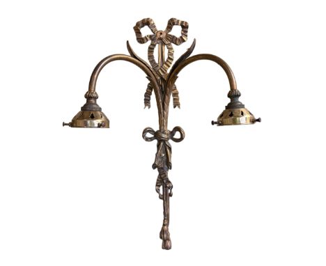 A set of three early 20th century English cast brass wall lights with ribbon tied foliate scroll backplates and fittings for 