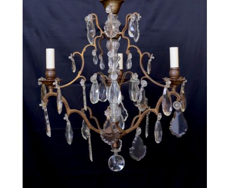 An early 20th century French bronze and cut glass three light chandelier, hung with tear shaped and faceted drops, width 50cm