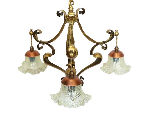 An early 20th century English Arts &amp; Crafts brass light fitting of Art Nouveau scrolling form with three associated tinte