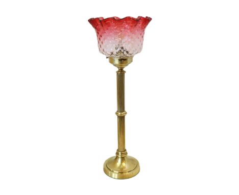 An early 20th century English brass table lamp with reeded stem and ruby tinted glass shade, height 51cm
***CONDITION REPORT*