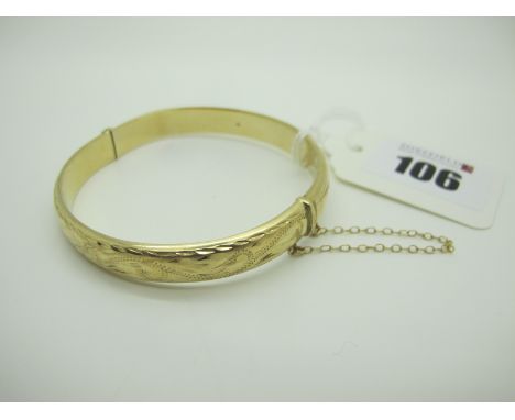 A 9ct Gold Hinged Bangle, scroll engraved to the front (dent / misshapen). 