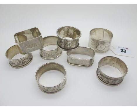 Eight Assorted Hallmarked Silver Napkin Rings, (various makers and dates) including engine turned decoration, initialled etc.