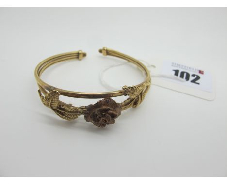 A 9ct Gold Bangle, with central rose detail (damage). 