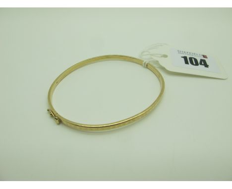 A Dainty Bangle, with engraved decoration, stamped "9kt". 