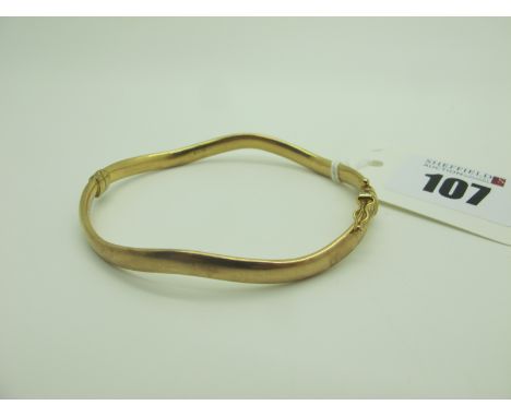 A Modern Hinged Bangle, of wavy design (sprung hinge) stamped "375" (overall weight 5.6grams). 