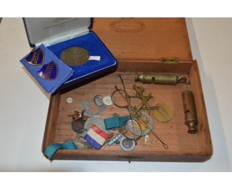 A box containing various medals, two whistle, enamel badges, etc.